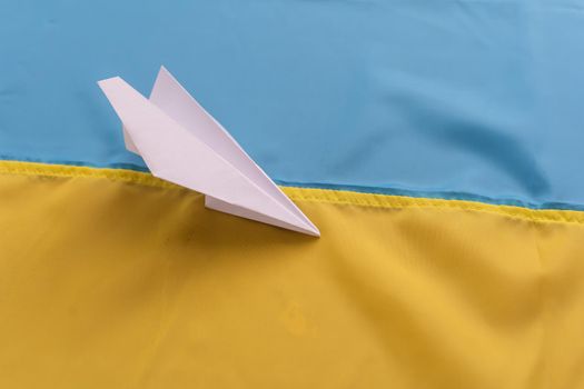 paper airplane on the background flag of Ukraine, flags of the country, blue, yellow.