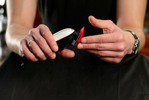 hands holding hair clipper. no face.