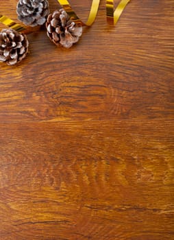 Composition of christmas decorations with pine cones and copy space on wooden background. christmas, tradition and celebration concept.