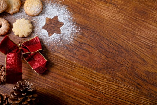 Composition of christmas decorations with christmas cookies and copy space on wooden background. christmas, tradition and celebration concept.