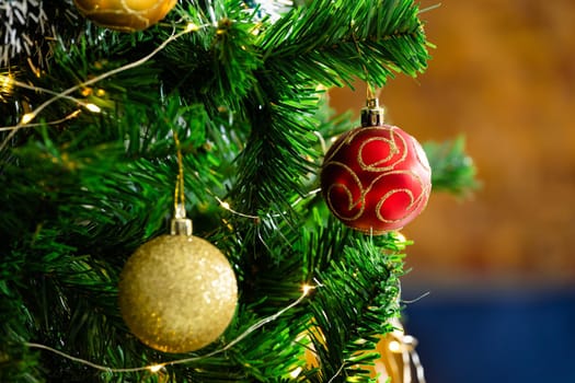 Composition of christmas tree with red and gold baubles on blurred background. christmas, tradition and celebration concept.