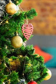 Composition of christmas tree with decorations and baubles on blurred background. christmas, tradition and celebration concept.