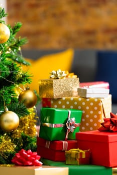 Composition of christmas tree and stacked presents on blurred background. christmas, tradition and celebration concept.