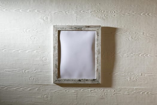 Composition of white card in frame with copy space on white background. interior design and decor concept.