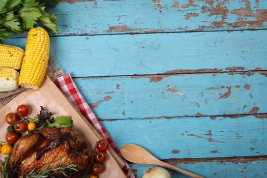 Cooked chicken and multiple food ingredients with copy space on blue wooden surface. food and restaurant concept