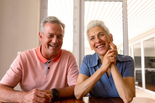 Happy caucasian senior couple having video call, looking at camera. healthy retirement lifestyle at home.