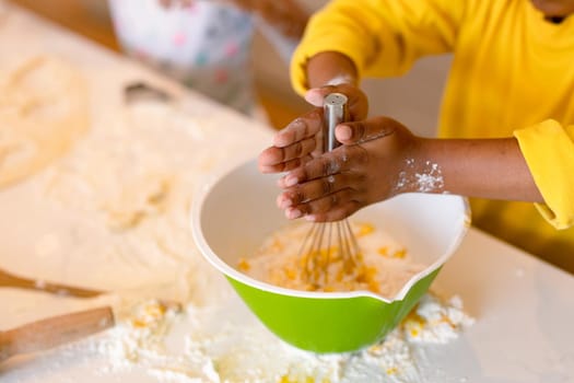 Hands of african american boy baking, mixing dough. baking and cooking, childhood and leisure time at home.