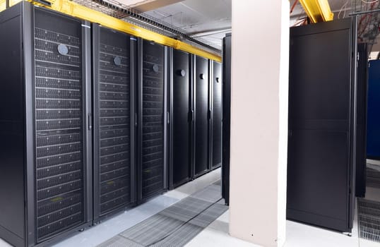 Data center with multiple rows of fully operational server racks. modern cloud computing technology concept.