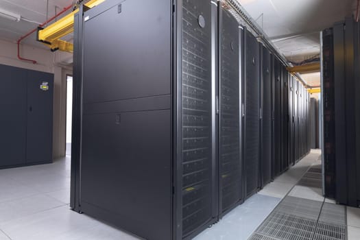 Data center with multiple rows of fully operational server racks. modern cloud computing technology concept.