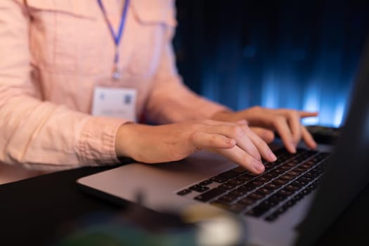 Mid section of woman using laptop in computer server room. database server management and maintenance concept