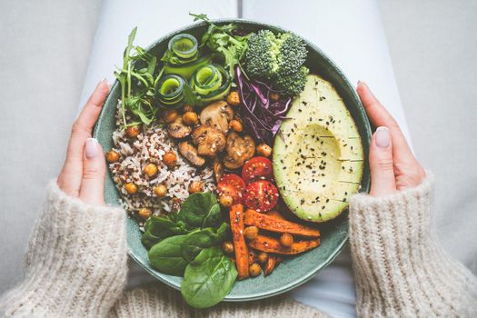 Woman holding plate with vegan or vegetarian food. Healthy plant based diet. Healthy dinner or lunch. Buddha bowl with fresh vegetables. Healthy eating. High quality photo