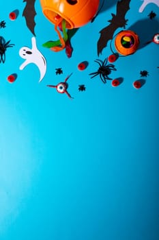 Close up view of multiple halloween candies and toys against blue background. halloween festivity and celebration concept