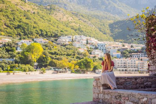 Woman tourist on background of beautiful view of the island of St. Stephen, Sveti Stefan on the Budva Riviera, Budva, Montenegro. Travel to Montenegro concept.