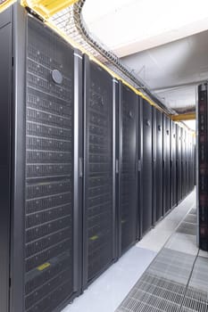 Data center with multiple rows of fully operational server racks. modern cloud computing technology concept.