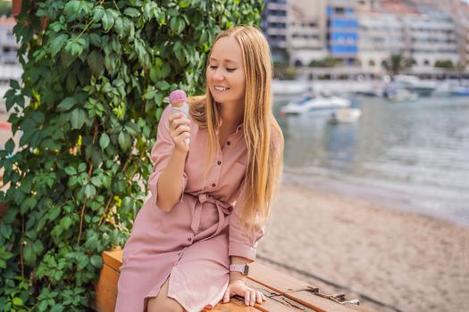 Close up of pretty tourist girl eating traditional gelato italian ice cream in a European town.