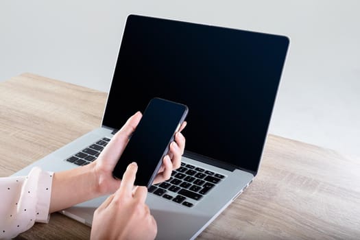 Midsection of caucasian businesswoman using laptop and smartphone, isolated on grey background. business, technology, communication and growth concept.