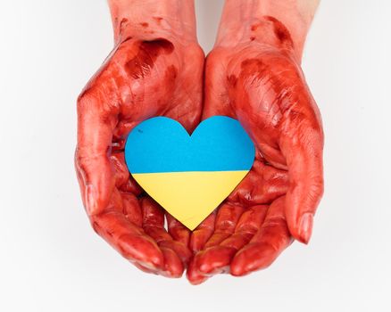 Woman with hands covered in blood holding a heart with the flag of ukraine on a white background