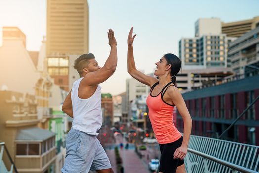 Shot of a young couple giving each other high five during their workout.