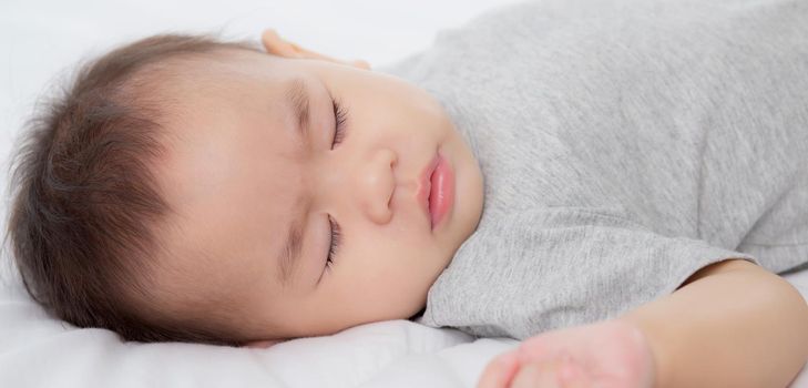 Portrait of asian little baby girl sleeping on bed in the bedroom at home, newborn napping with cozy and relax, infant innocence in bedtime, happy toddler cute, growth of child and emotion, indoors.