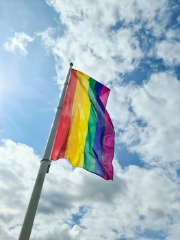 Rainbow pride flag illustration. Lgbt community symbol in rainbow colors against the blue sky 