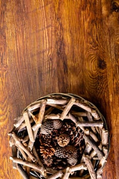 Composition of christmas decorations with sticks, pine cones and copy space on wooden background. christmas, nature, tradition and celebration concept.