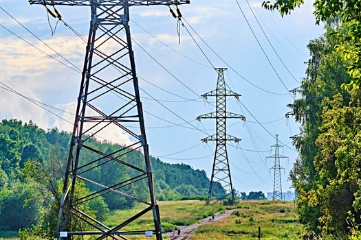 A long line of electrical transmission towers carrying high voltage lines.