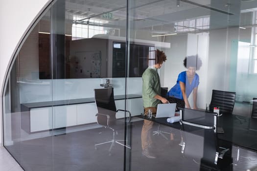 Diverse male and female colleagues in office discussing over blueprint document. independent creative design business.