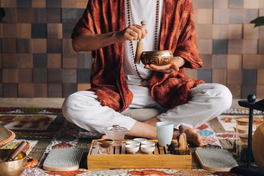 Tibetan singing bowl in the hands of a man during a tea ceremony.