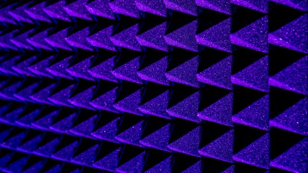 Background image of recording studio sound dampening acoustical foam.