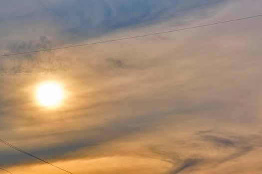 Sun illuminates feather clouds. general plan. day light. color