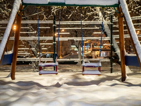 children's swing covered with snow