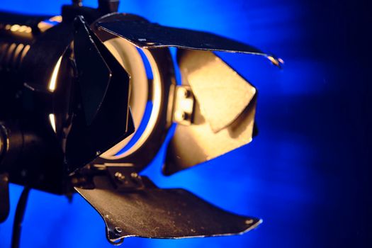 Close-up of a professional lighting fixture on a set or photographic studio. Concept of shooting a movie. color