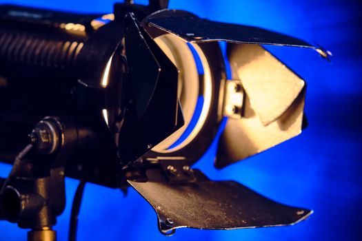 Close-up of a professional lighting fixture on a set or photographic studio. Concept of shooting a movie. color