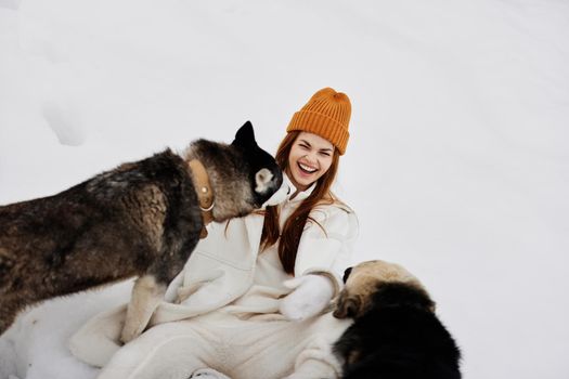 Happy young woman in the snow playing with a dogs fun friendship fresh air. High quality photo
