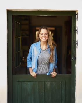 Portrait of an attractive young woman standing by her back door.