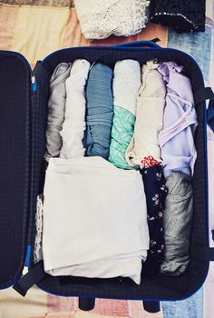 High angle shot of a suitcase packed with clothing.