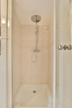 Shower room, lined with beige tiles in brick style in a modern house