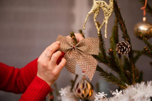 A woman decorates a Christmas tree for Christmas in the traditional way adopted in Poland. An annual Christmas ritual.