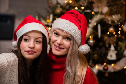 Family selfie in front of Christmas tree. Smiling girls during Christmas time in Poland.