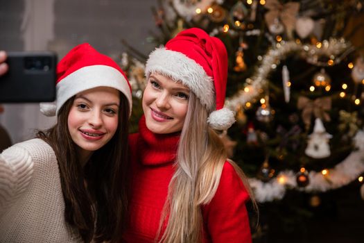 Family selfie in front of Christmas tree. Smiling girls during Christmas time in Poland.