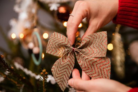 A woman decorates a Christmas tree for Christmas in the traditional way adopted in Poland. An annual Christmas ritual.