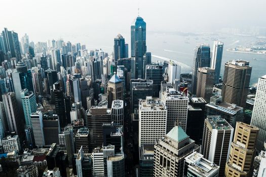 Aerial shot of skyscrapers, office blocks and other commercial buildings in a busy coastal city.