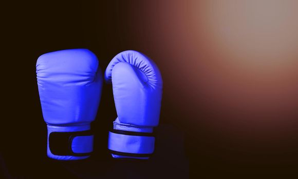 Blue boxing gloves in sport on black