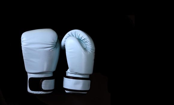 Blue boxing gloves in sport on black