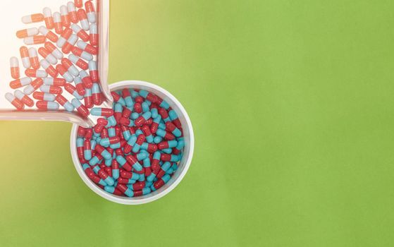 pouring pills on tray on color background