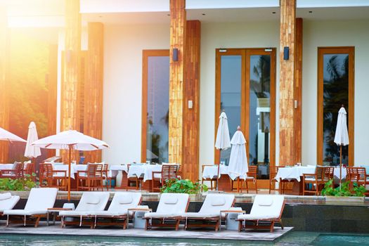 Beach front of hotel in day time and crouch and umbrella