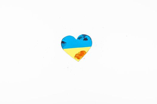 Heart with the flag of Ukraine is smeared with blood on a white background