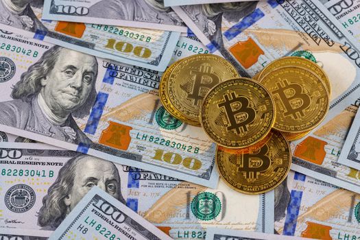 yellow bitcoin coins scattered over US dollar paper banknotes, cryptocurrency and fiat money exchange concept