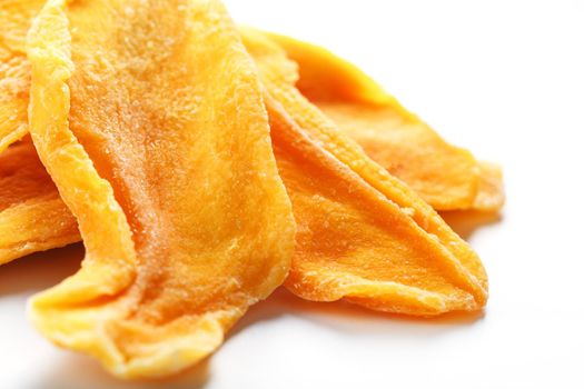 Organic dried mango fruit slices isolated on white background