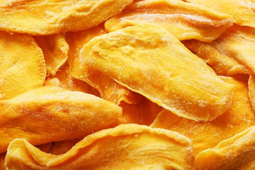 Pieces of sweet dried mango close-up as a background in full screen top view